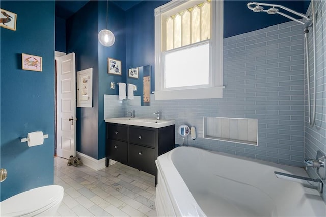 bathroom with tile patterned flooring, vanity, a washtub, toilet, and tile walls