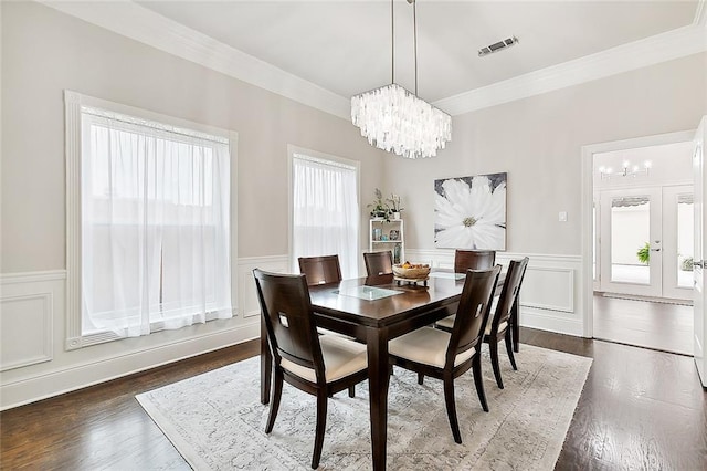 dining area with ornamental molding, dark hardwood / wood-style flooring, and an inviting chandelier