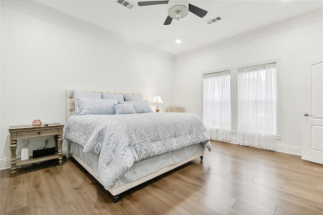 bedroom featuring hardwood / wood-style floors, ceiling fan, and crown molding