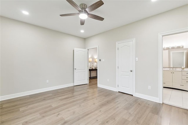 unfurnished bedroom with light hardwood / wood-style floors, ceiling fan, ensuite bath, and sink