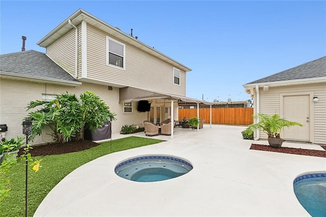 rear view of property with a swimming pool with hot tub, a patio, and an outdoor living space