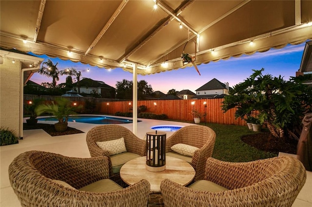 patio terrace at dusk with a swimming pool with hot tub