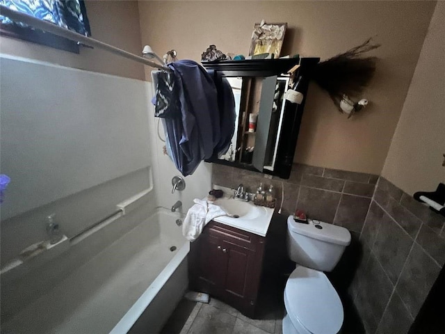 full bathroom featuring tile walls, vanity,  shower combination, and toilet