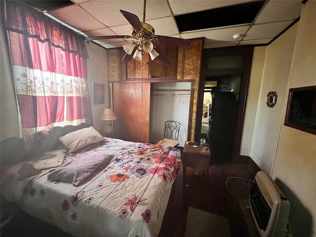 bedroom featuring a closet, a paneled ceiling, ceiling fan, and heating unit