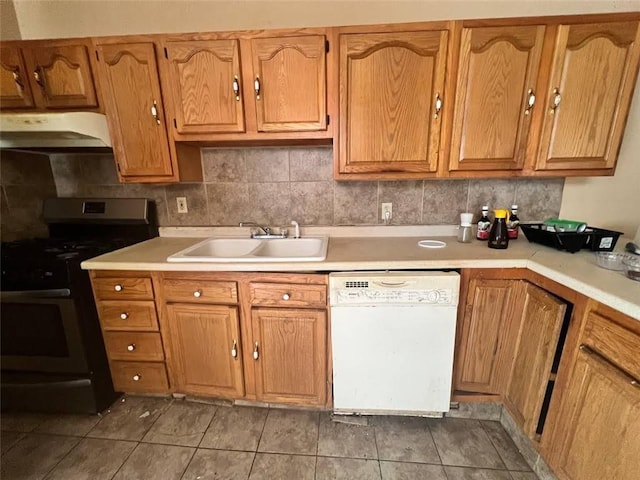 kitchen featuring dishwasher, black gas range, light tile patterned floors, and sink