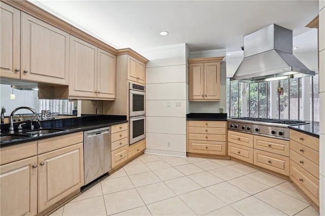 kitchen featuring dark stone counters, light tile patterned floors, light brown cabinetry, appliances with stainless steel finishes, and extractor fan