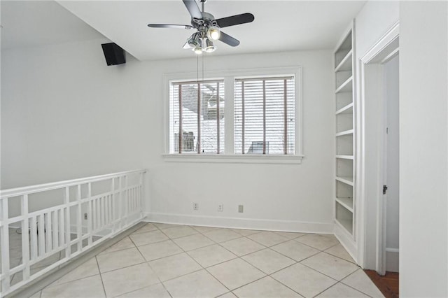 tiled empty room featuring ceiling fan