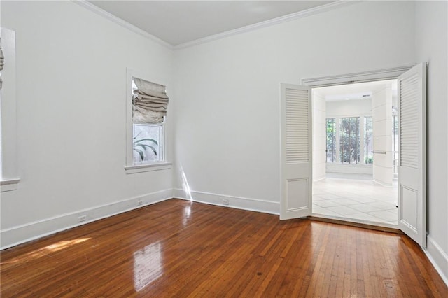 empty room with crown molding and wood-type flooring