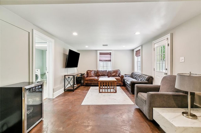 living room with a wealth of natural light, beverage cooler, and washer / dryer