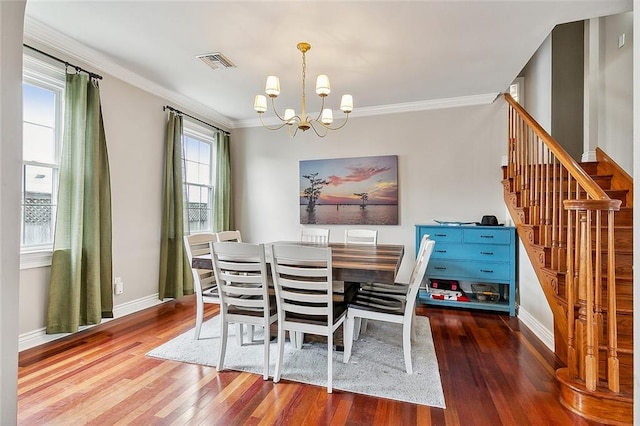 dining space with an inviting chandelier, hardwood / wood-style floors, and ornamental molding