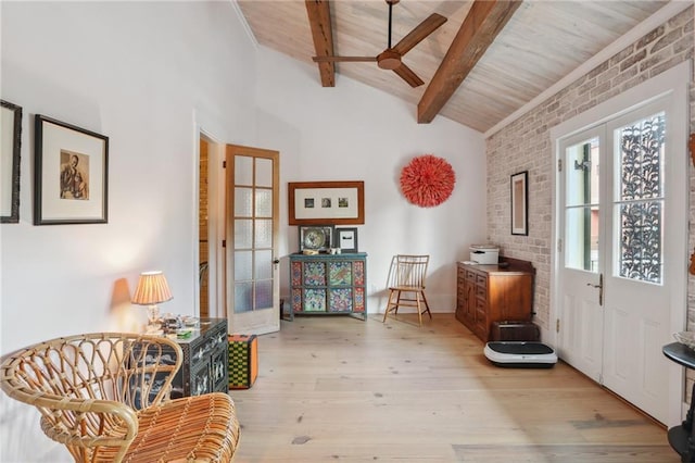 living area with beam ceiling, light hardwood / wood-style floors, brick wall, wooden ceiling, and french doors