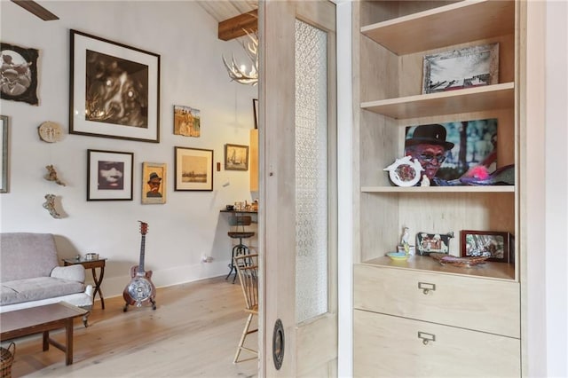 interior space with light hardwood / wood-style floors, built in features, and a notable chandelier