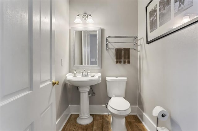 bathroom with hardwood / wood-style flooring and toilet