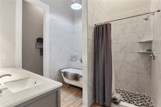 bathroom with wood-type flooring, vanity, separate shower and tub, and tile walls