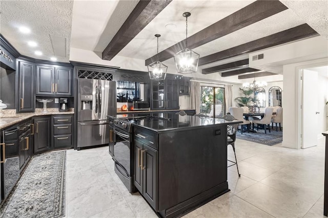 kitchen with stainless steel refrigerator with ice dispenser, hanging light fixtures, a textured ceiling, beam ceiling, and dark stone countertops