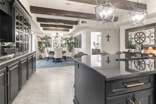 kitchen featuring pendant lighting, light tile patterned flooring, a center island, and beam ceiling