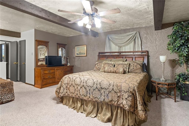 bedroom featuring beam ceiling, a textured ceiling, ceiling fan, and carpet floors