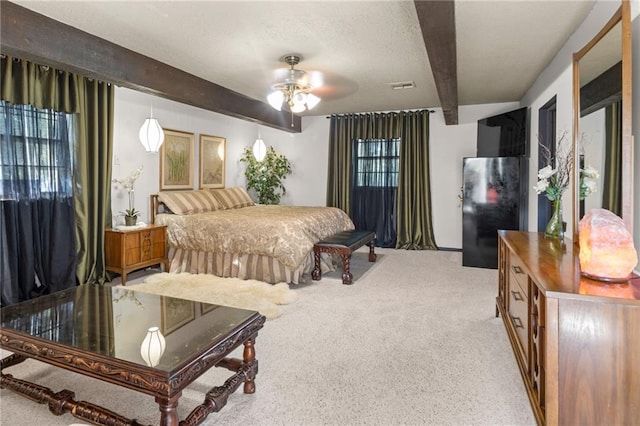 bedroom with a textured ceiling, light colored carpet, ceiling fan, and beam ceiling