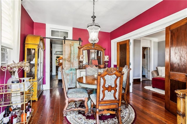 dining room featuring dark wood-type flooring and a barn door