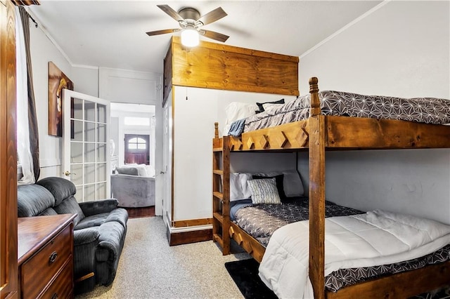 bedroom featuring ceiling fan, crown molding, and carpet floors