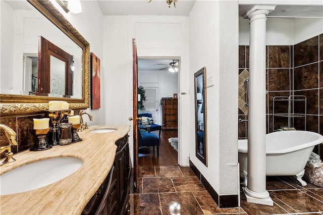 bathroom featuring a tub to relax in, ceiling fan, hardwood / wood-style floors, vanity, and decorative columns