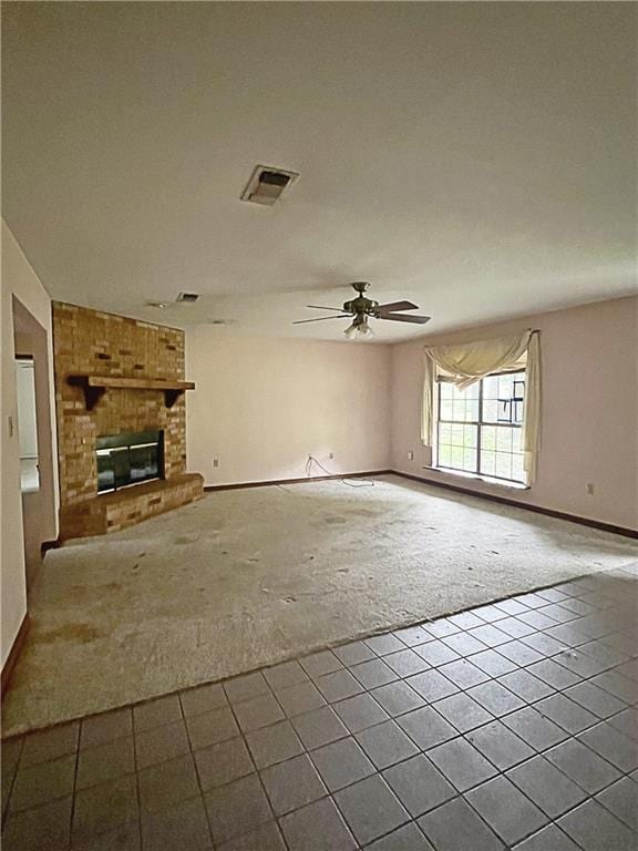 unfurnished living room featuring carpet flooring, ceiling fan, and a brick fireplace