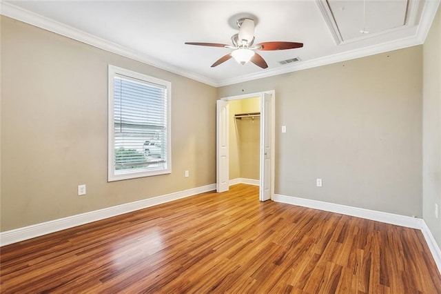 unfurnished bedroom featuring ceiling fan, a closet, light hardwood / wood-style flooring, and crown molding