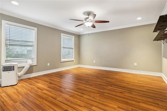 spare room with ceiling fan, wood-type flooring, plenty of natural light, and ornamental molding