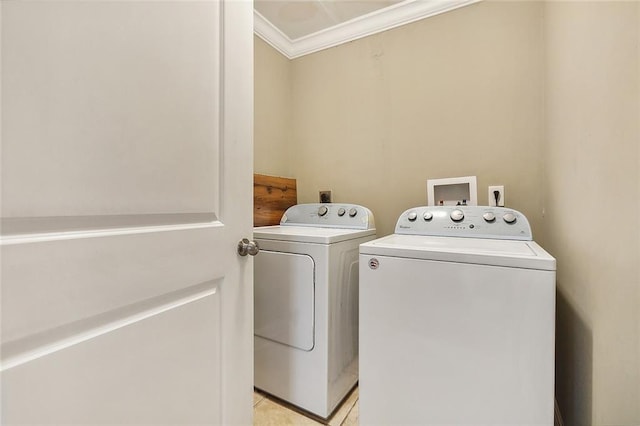 clothes washing area featuring washer and clothes dryer, light tile patterned flooring, and crown molding