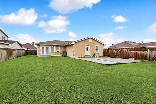 rear view of house featuring central air condition unit, a lawn, and a patio