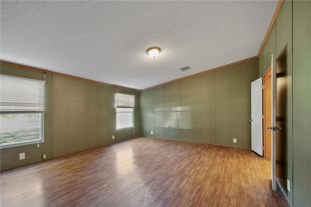 spare room with ornamental molding, light hardwood / wood-style flooring, and a healthy amount of sunlight