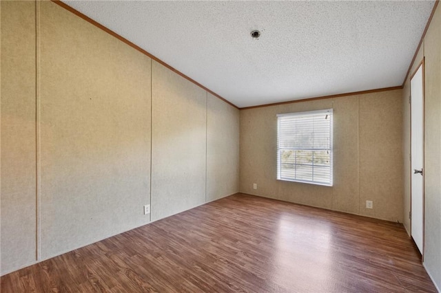 empty room with wood-type flooring and a textured ceiling