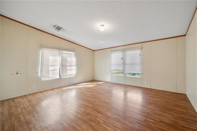 spare room featuring a textured ceiling, wood-type flooring, and lofted ceiling