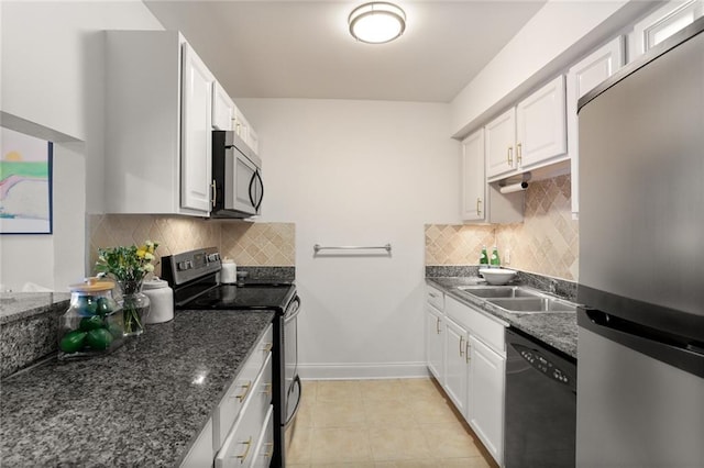 kitchen with dark stone counters, white cabinetry, appliances with stainless steel finishes, backsplash, and light tile patterned floors