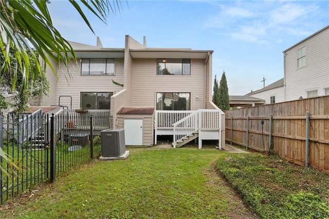 back of house featuring central air condition unit, a lawn, and a deck