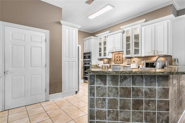 60168 Peach Orchard Blvd, Bogalusa, LA 70427 - kitchen featuring dark stone counters, stainless steel appliances, white cabinets, glass insert cabinets, and light tile patterned flooring
