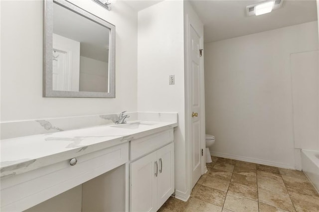 bathroom with a bathtub, vanity, and toilet