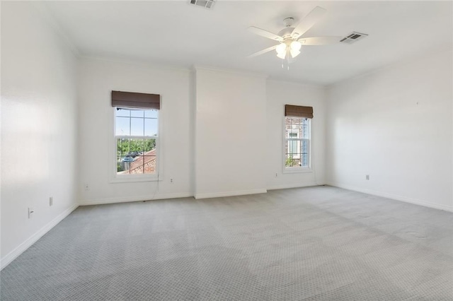 carpeted spare room with crown molding, a healthy amount of sunlight, and ceiling fan