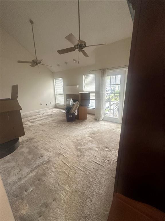 interior space featuring a high ceiling, ceiling fan, and carpet floors