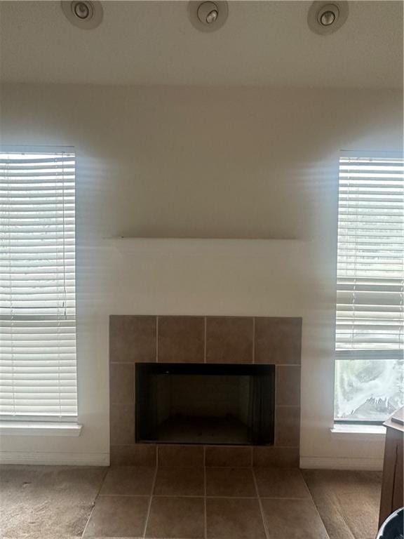 room details featuring a tiled fireplace and tile patterned flooring