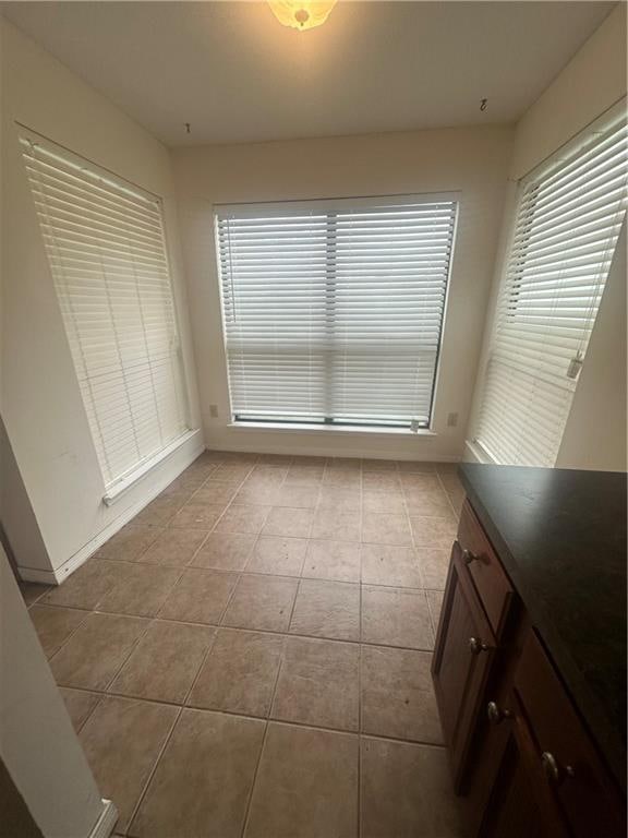 unfurnished dining area featuring light tile patterned flooring