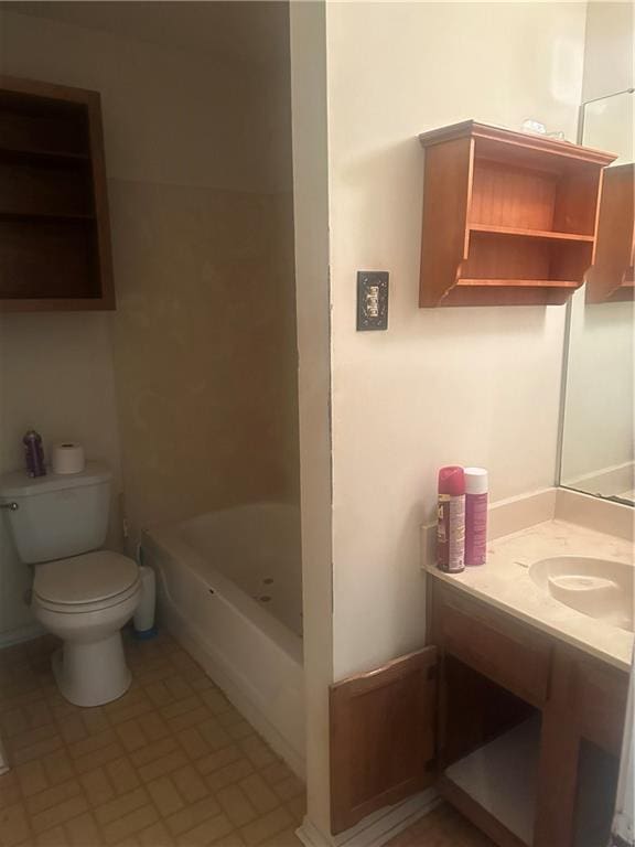 bathroom with a washtub, vanity, and toilet