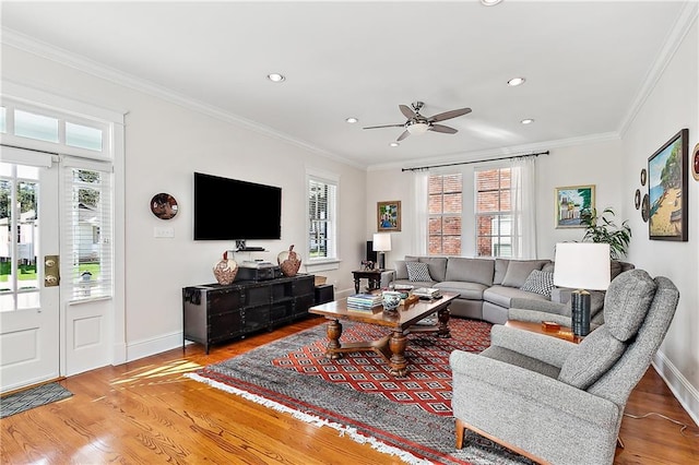 living room with ornamental molding, light hardwood / wood-style flooring, and ceiling fan