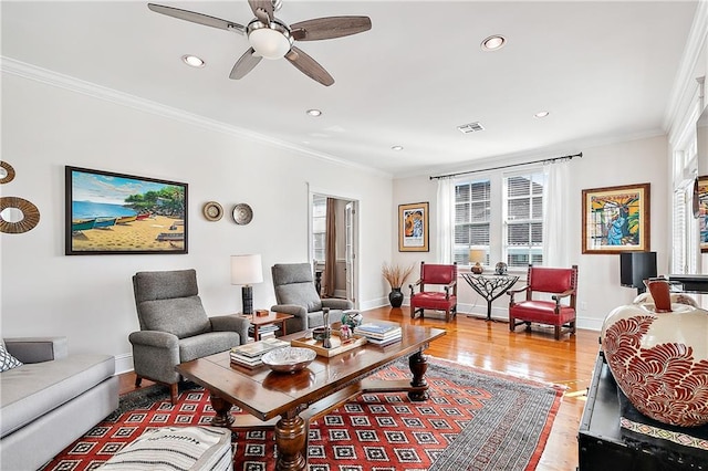 living room with hardwood / wood-style floors, ceiling fan, and crown molding