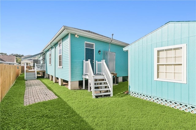 back of house featuring a wooden deck and a yard