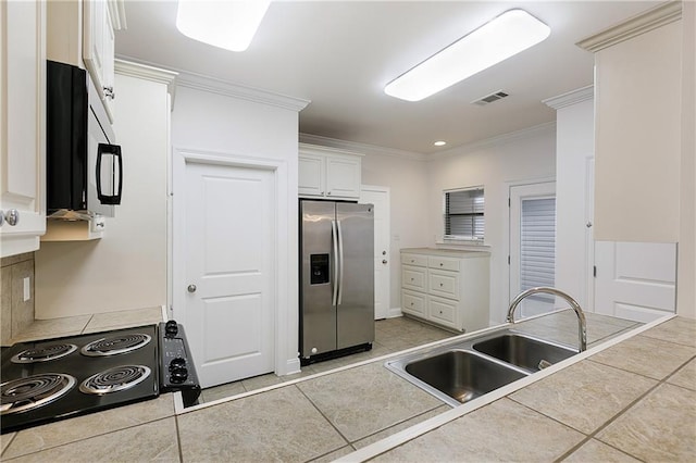 kitchen with tile counters, sink, ornamental molding, white cabinetry, and stainless steel fridge