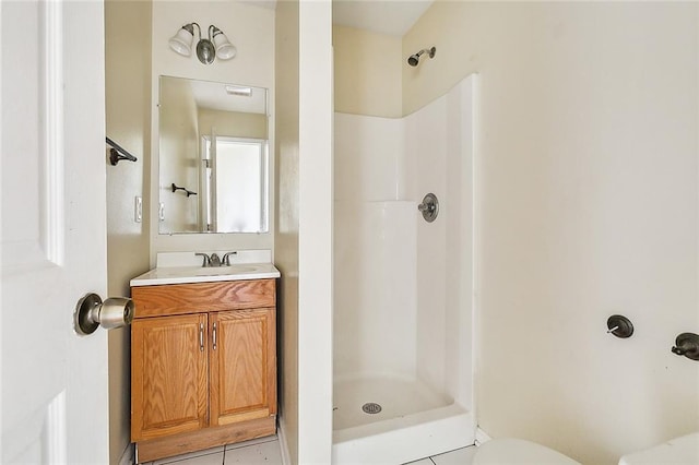 bathroom featuring walk in shower, toilet, vanity, and tile patterned floors