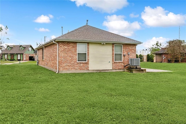 back of house featuring cooling unit and a lawn