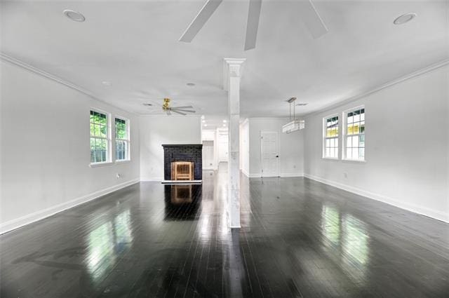 unfurnished living room with ceiling fan, a fireplace, dark wood-type flooring, and ornamental molding