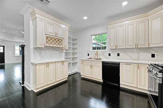 kitchen featuring backsplash, dishwasher, sink, and stainless steel stove